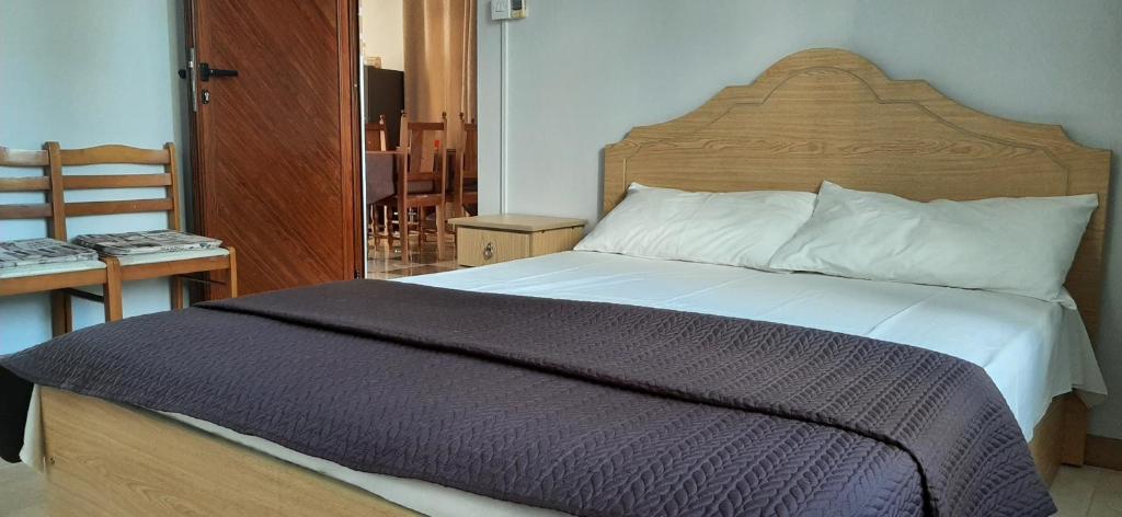 a bedroom with a large bed with a wooden headboard at Ground Floor Lovely two bedrooms apartment in Flic-en-Flac