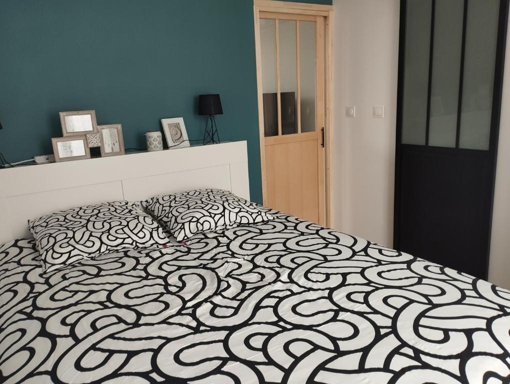 une chambre avec un lit avec une couette noire et blanche dans l'établissement La Cité du 56, à Dijon