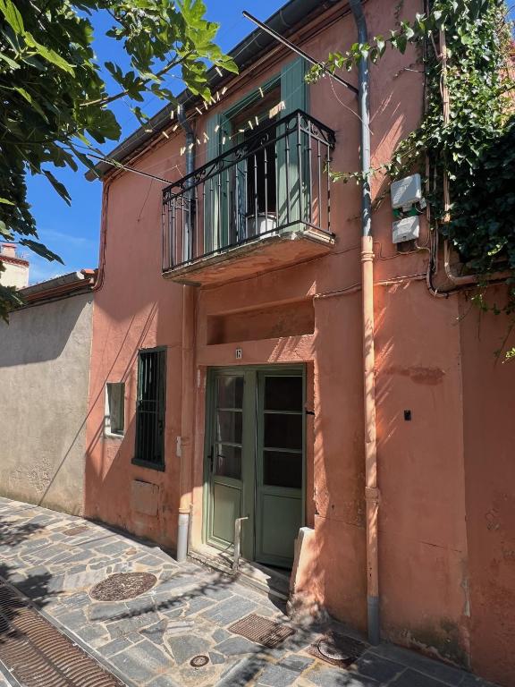 un bâtiment rose avec une porte verte et un balcon dans l'établissement Loft entièrement rénové, à Collioure