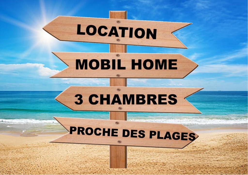 - un panneau en bois sur une plage avec la maison de Wordsocation moolahu dans l'établissement Mobil home 3 chambres Saint-Jean-de-Monts, à Saint-Jean-de-Monts