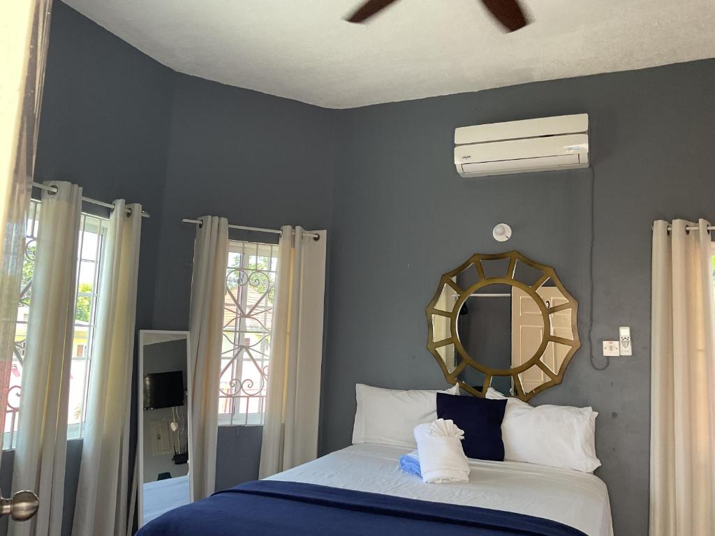 a bedroom with a bed with a mirror on the wall at A taste of Jamaica Lavern’s Place in Ocho Rios