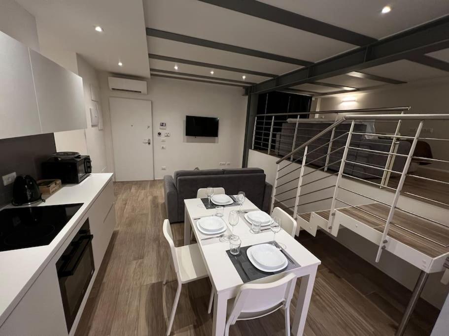 a kitchen with a white table and chairs in a room at Ariosti 3 - Piazza Maggiore in Bologna