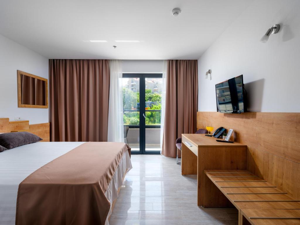 una camera d'albergo con un letto e una televisione di Hotel D'Elegant Dubrovnik a Dubrovnik