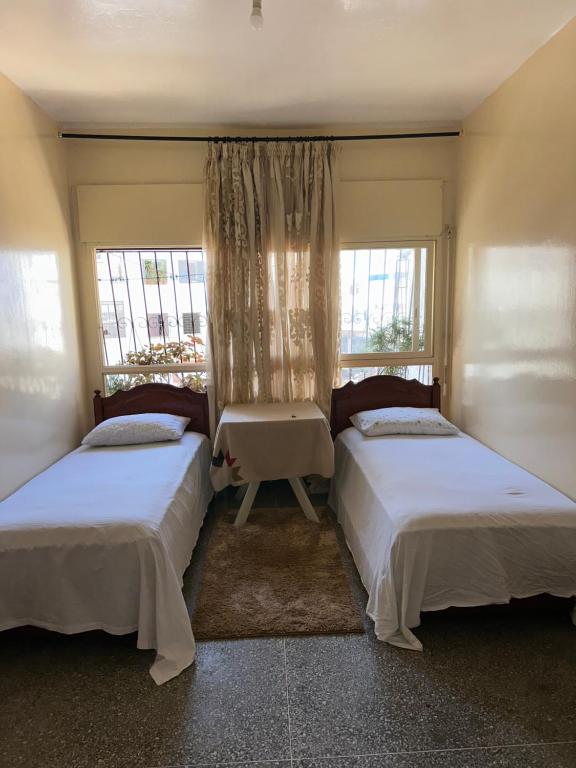 2 letti in una camera con 2 finestre di Chambre cosy au cœur de Rabat a Rabat