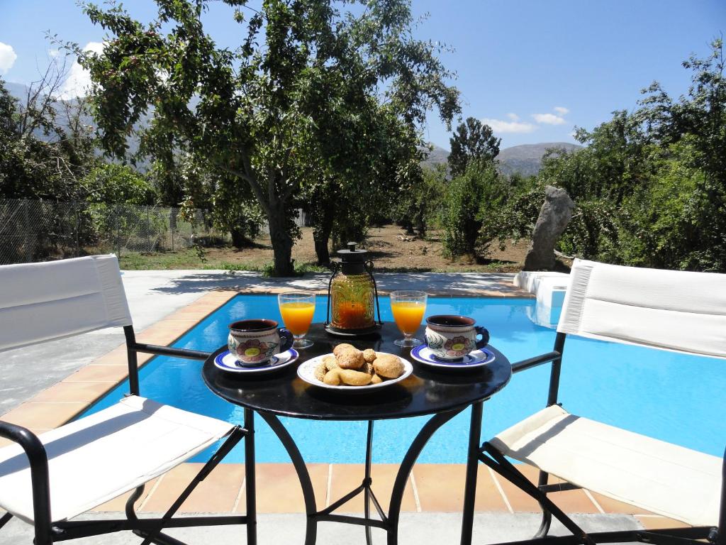 een tafel met eten naast een zwembad bij Zeus House in Agios Konstantinos