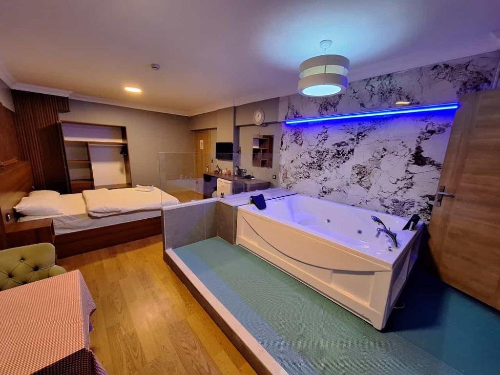 un ampio bagno con vasca e letto di Emsa Otel Maltepedeki Eviniz a Istanbul