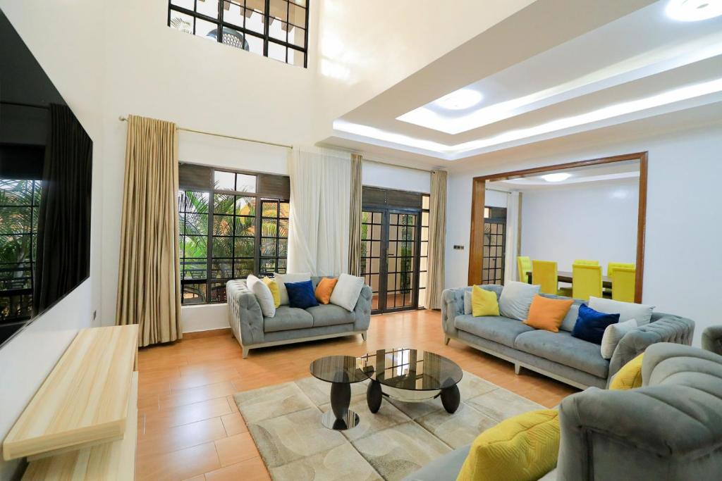 a living room with two couches and a table at Lux Holidays Villa in Kigali