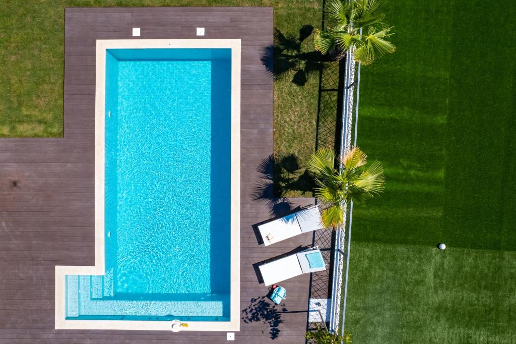 an overhead view of a swimming pool with palm trees at Villa Florinda with Pool and Prime Location near Split in Srinjine