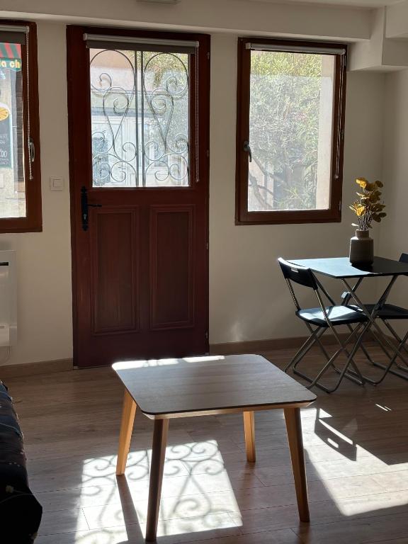 une chambre avec une table, une table et une porte dans l'établissement Studio au cœur du vieux village, à Vitrolles