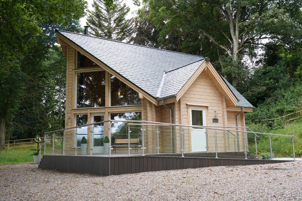 una piccola casa con una grande finestra e un tetto di Cherry Tree Lodge a Inverness