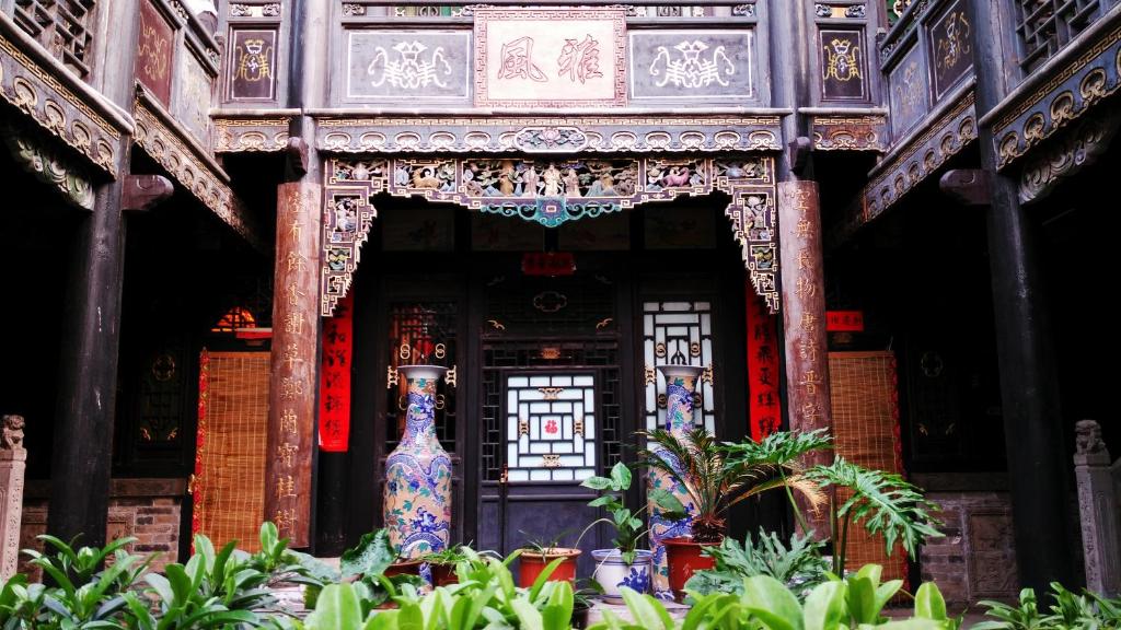 an entrance to a building with a vase in front at Pingyao Zheng Garden Inn in Pingyao