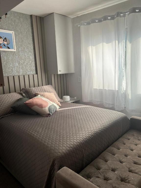 um quarto com uma cama grande e uma janela em APTO BEIRA MAR BALNEARIO CAMBORIU no Balneário Camboriú