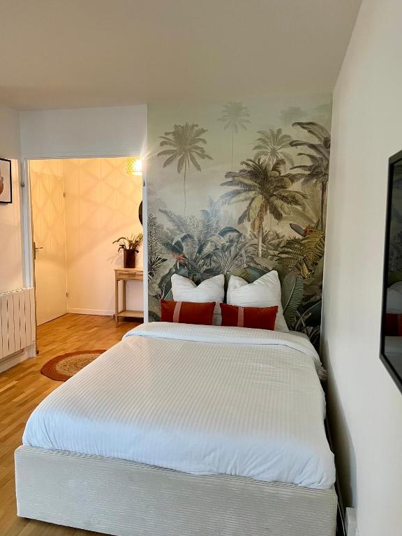 une chambre avec un lit blanc avec des oreillers rouges dans l'établissement Appartement Rénové au Cœur du Quartier Commerçant, à Colombes