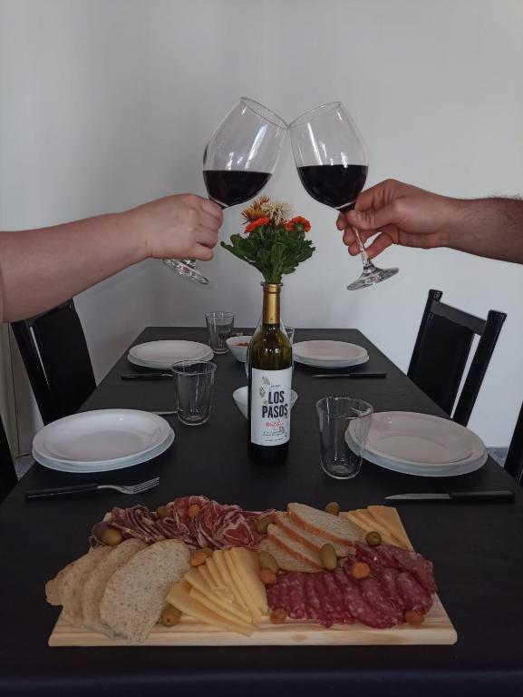 a table with two people holding glasses of wine at RyM Departamentos in Barraquero