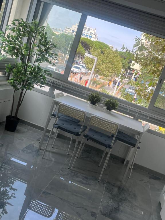 une table et deux chaises devant une fenêtre dans l'établissement Studio, vu latéral mer, à La Grande Motte