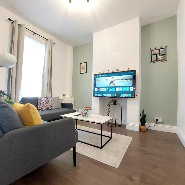 a living room with a couch and a tv at Amber Lodge- No party Room in Belfast