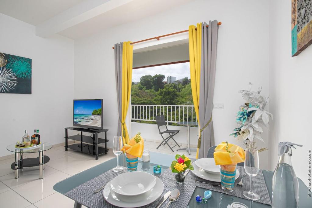 a dining room with a table and a view of the ocean at Verveine au Refuge de Madiana in Schœlcher