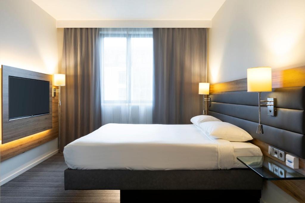 a hotel room with a bed and a television at Moxy Aberdeen Airport in Dyce