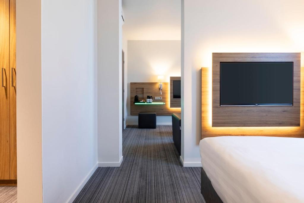a hotel room with a bed and a flat screen tv at Moxy Aberdeen Airport in Dyce