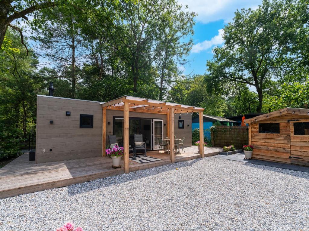 a tiny house with a deck and a patio at Lodge in Hattemerbroek near Veluwe Forest in Hattemerbroek