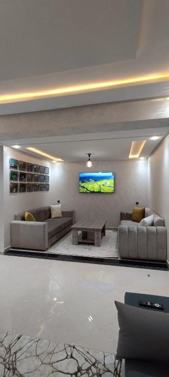 uma sala de estar com sofás e uma TV de tela plana em APPART-HOTEL La MAISON ATTAWBA 2 em Beni Mellal