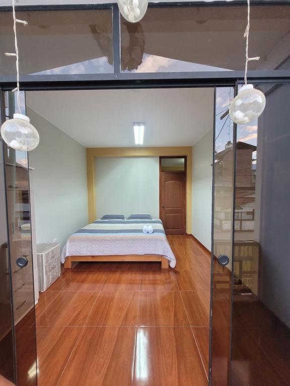 a bedroom with a bed and a glass wall at 1era Habitación privada a 1 cuadra del parque in Oxapampa