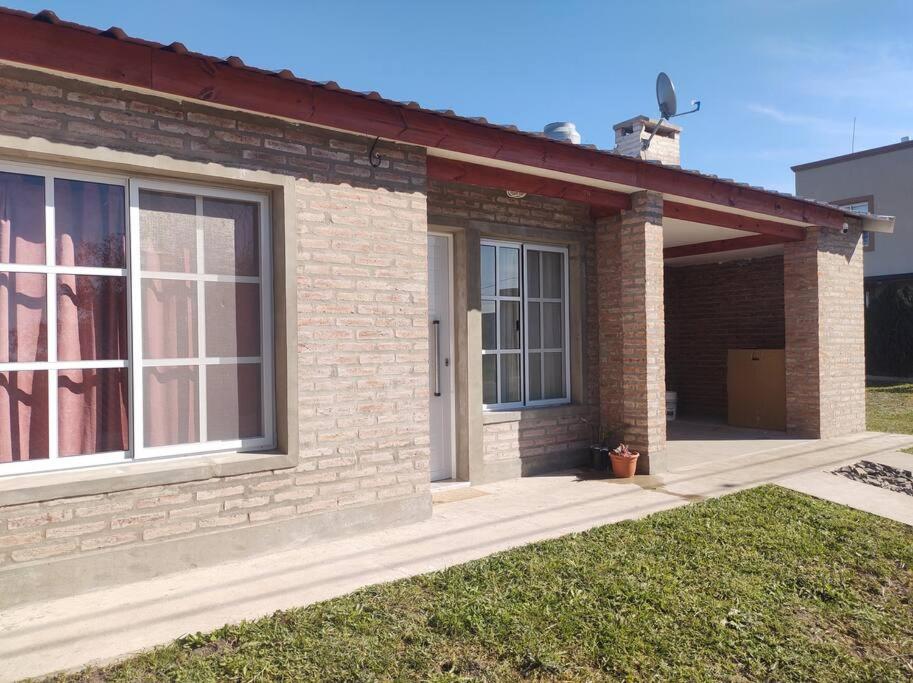 a brick house with a front door and windows at Los Fresnos Casa Quinta in La Picada