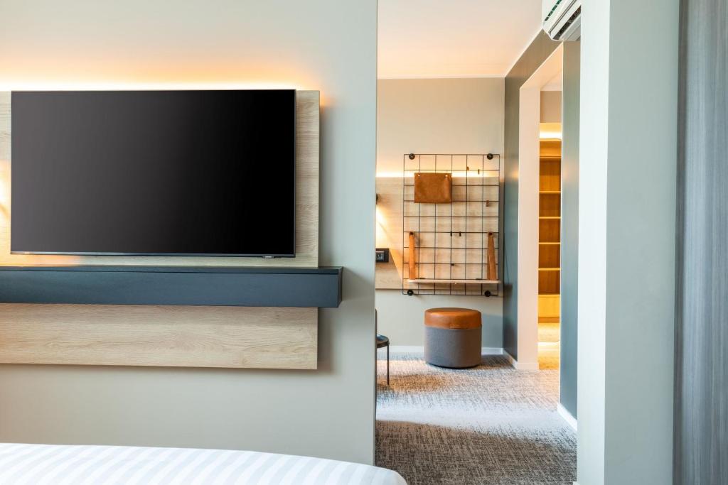 a living room with a television on a wall at Moxy Berlin Airport in Schönefeld