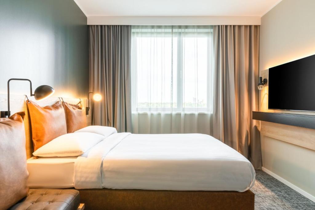a hotel room with a bed and a television at Moxy Berlin Airport in Schönefeld
