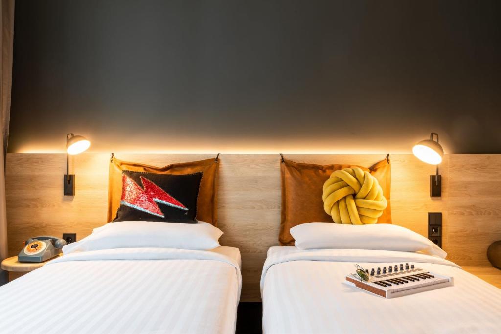 two beds sitting next to each other in a room at Moxy Berlin Airport in Schönefeld