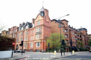 un gran edificio de ladrillo rojo en una calle de la ciudad en London Kensington & Chelsea 2 Bed Zone 1 Aprt, en Londres