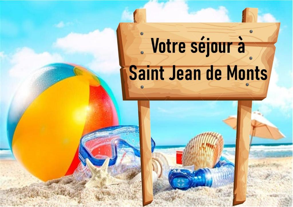 - un panneau sur une plage de sable avec un ballon de plage dans l'établissement Mobil home 2 chambres Saint-Jean-de-Monts, à Saint-Jean-de-Monts