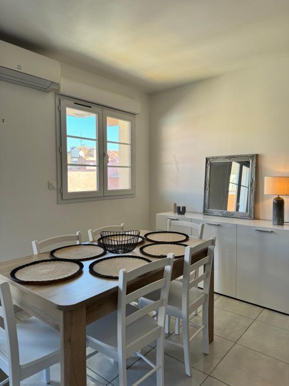 une salle à manger avec une table et des chaises blanches dans l'établissement T3 Vue sur le port, à Ajaccio