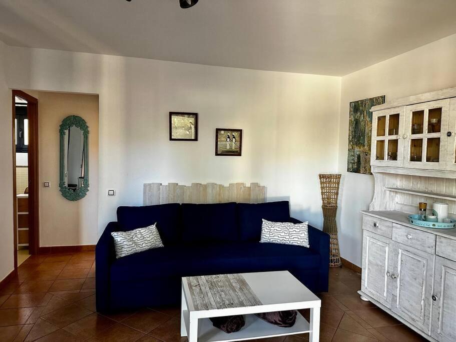 a living room with a blue couch and a fireplace at Cabaña Amida in Lajares