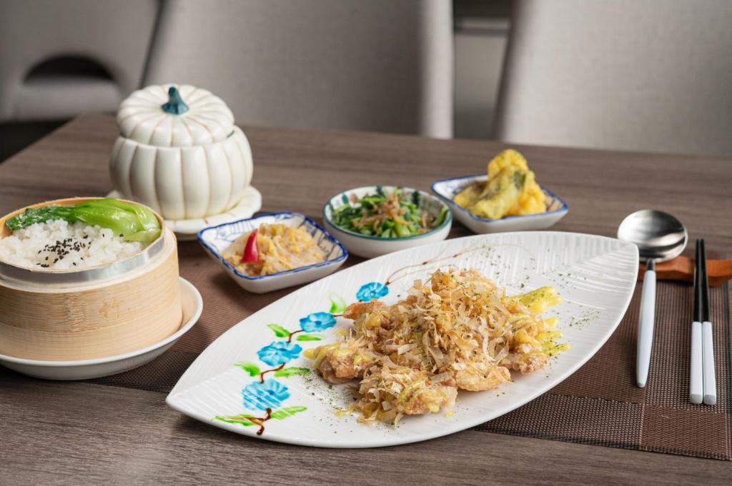 a plate of food on a table with bowls of food at TH Hotel in Pingtung City