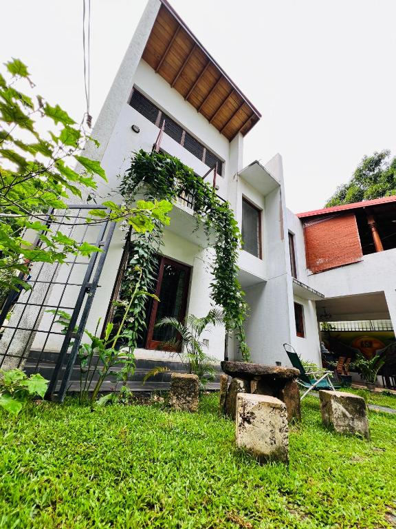 a house with a green yard in front of it at Eco Boutique Villa in Gurudeniya