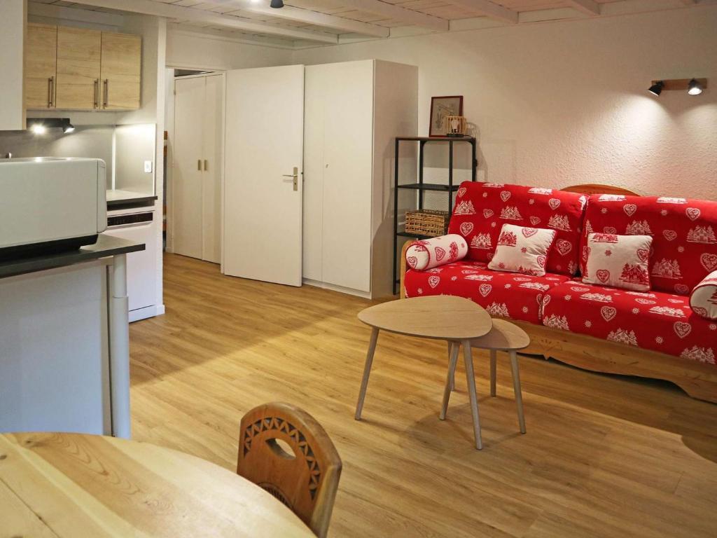un salon avec un canapé rouge et une table dans l'établissement Grand studio rénové 4 pers, centre station, départ skis aux pieds - FR-1-322-640, aux Orres