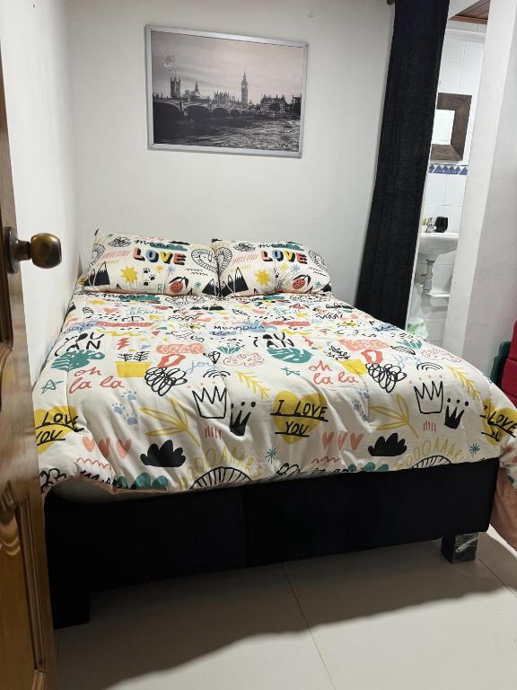 a bed with a comforter and pillows in a bedroom at Casa central popa in Cartagena de Indias
