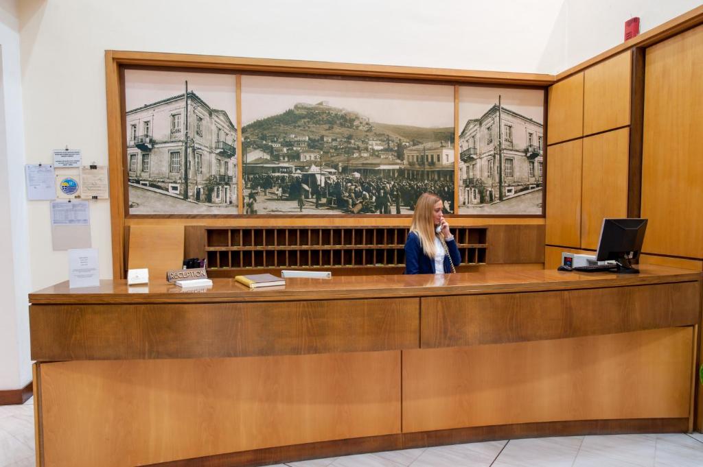 a woman talking on a phone at a reception desk at Fthia Hotel in Lamía