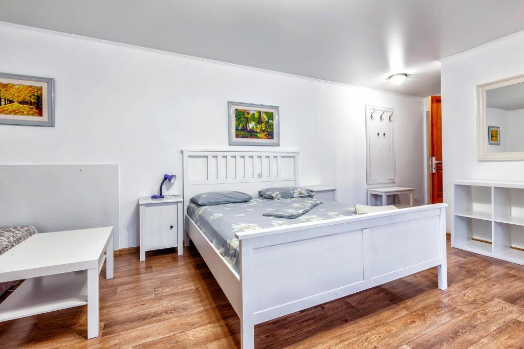 Un dormitorio blanco con una cama y un escritorio. en Lermontov apartments - Traveler's Choice in the City Center, en Almaty