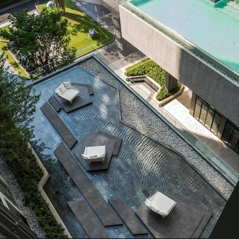 an overhead view of a swimming pool with two tables and chairs at The Base Central Pattaya by Mickey in Pattaya