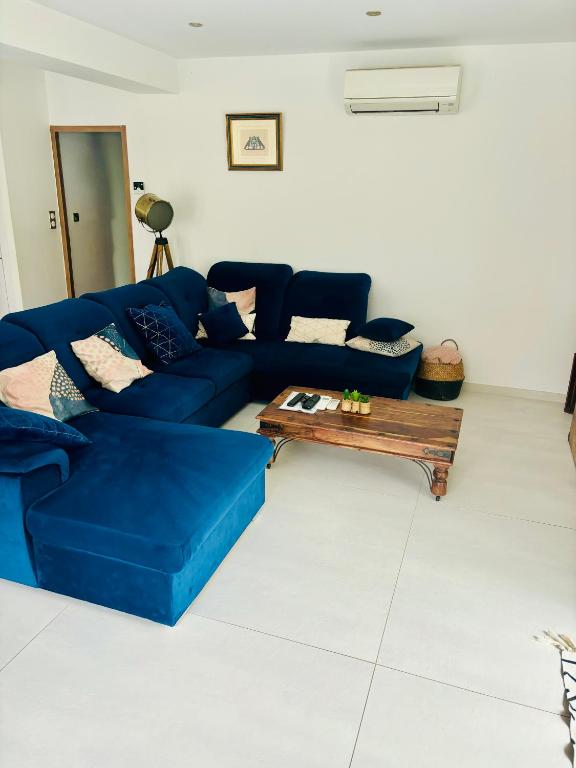 un salon avec un canapé bleu et une table basse dans l'établissement Magnifique Villa piscine, à Fabrègues
