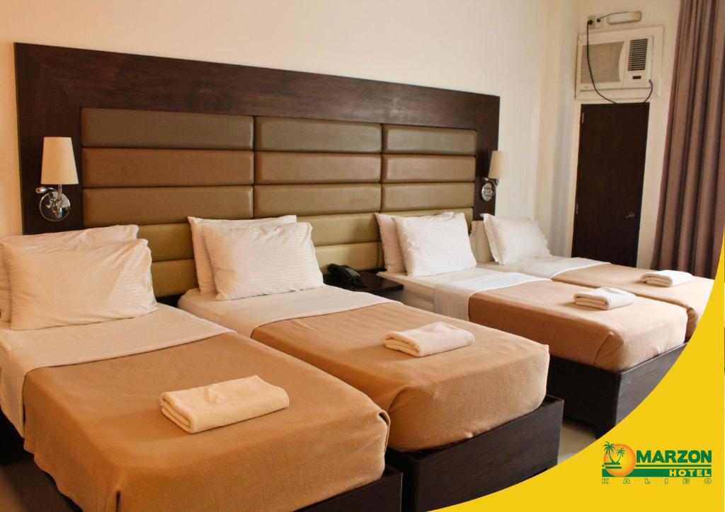Postel nebo postele na pokoji v ubytování MARZON HOTEL KALIBO