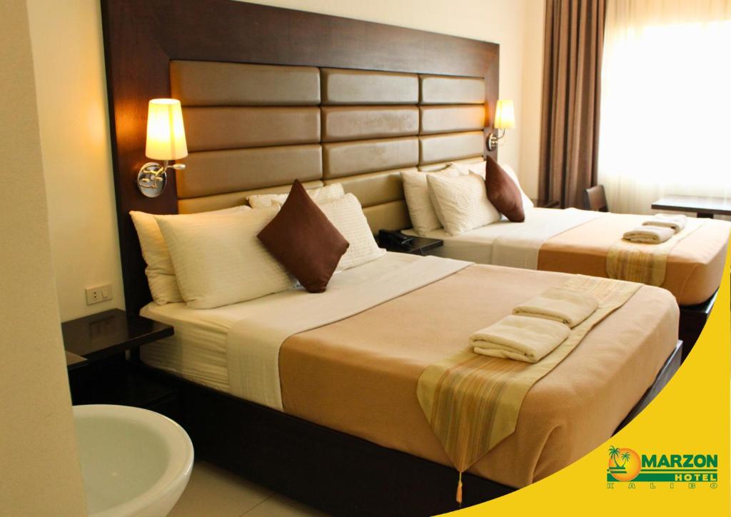 Postel nebo postele na pokoji v ubytování MARZON HOTEL KALIBO