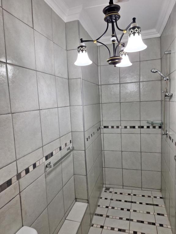 bagno con doccia e lampadario pendente di 21on2nd Avenue a Tzaneen