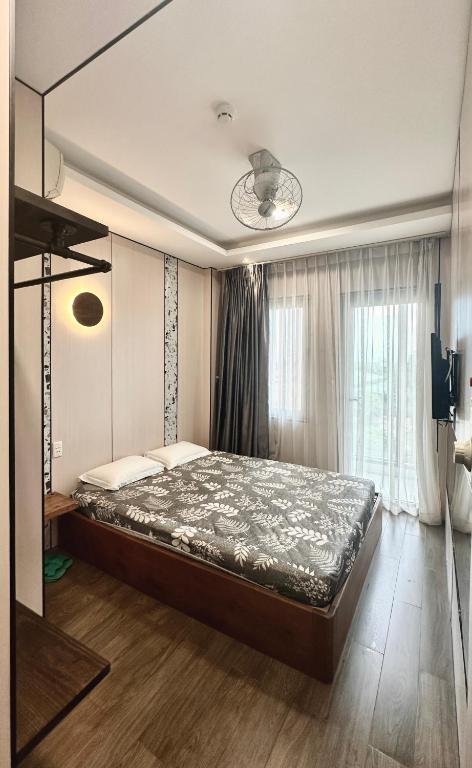 a bedroom with a large bed in front of a window at Mộc Trà Hotel in Ho Chi Minh City