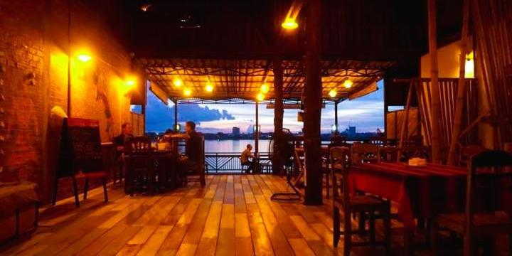a restaurant with a view of the water at night at Villa Sala Vanna in Savannakhet