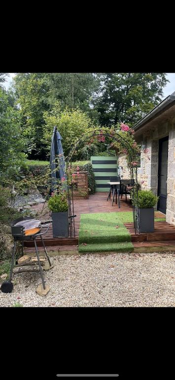 une arrière-cour avec une terrasse dotée d'une table et d'un grill dans l'établissement Studio d’étape, robinson Plaintel, à Plaintel