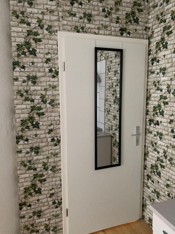 a mirror on a wall with a brick wall at HD Rooms in Bremen