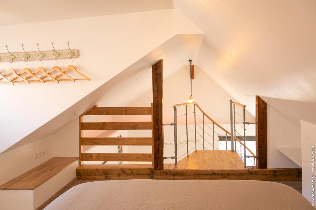 a staircase in a bedroom with a bed and a stair case at Les Cigognes de Rosheim in Rosheim